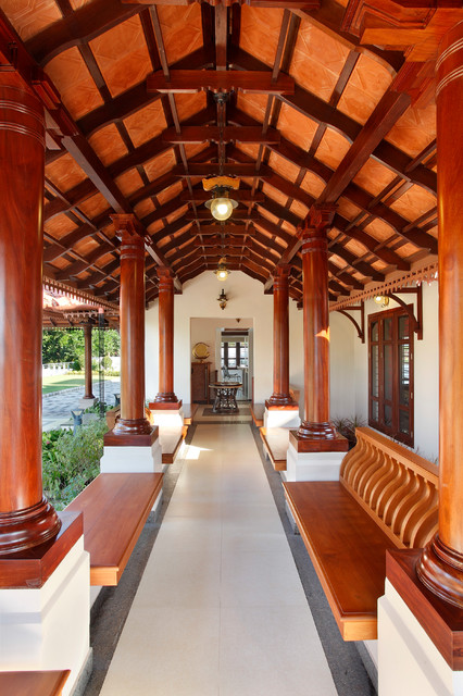 A corridor with a terracotta tiled roof showcases traditional architecture with its large wooden columns and beams.