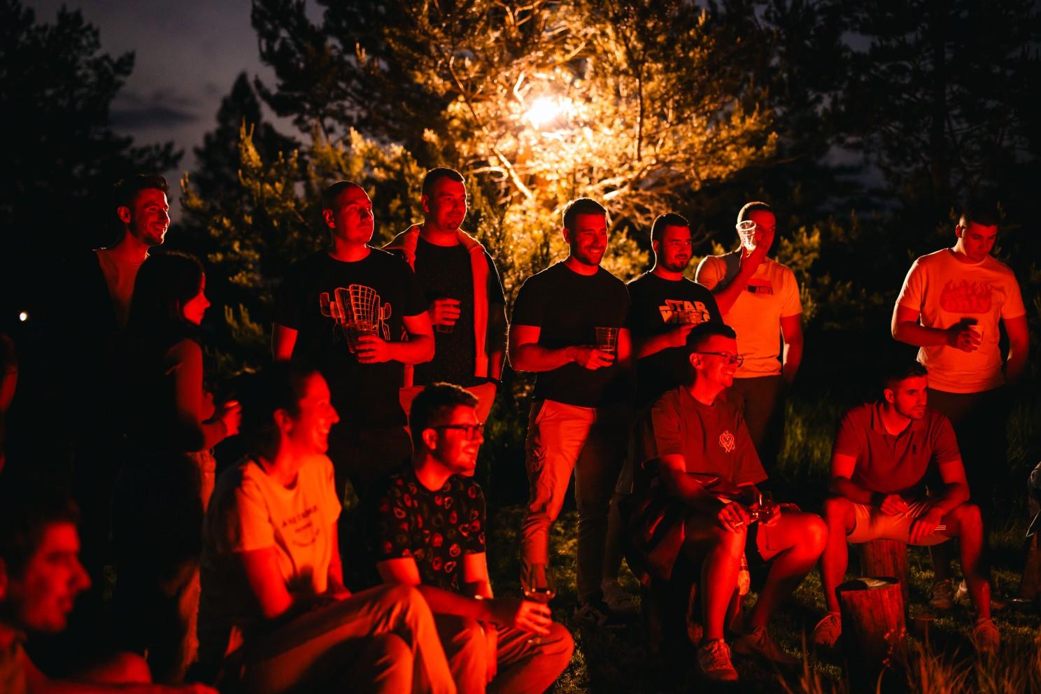 A group of people standing in front of a light

Description automatically generated