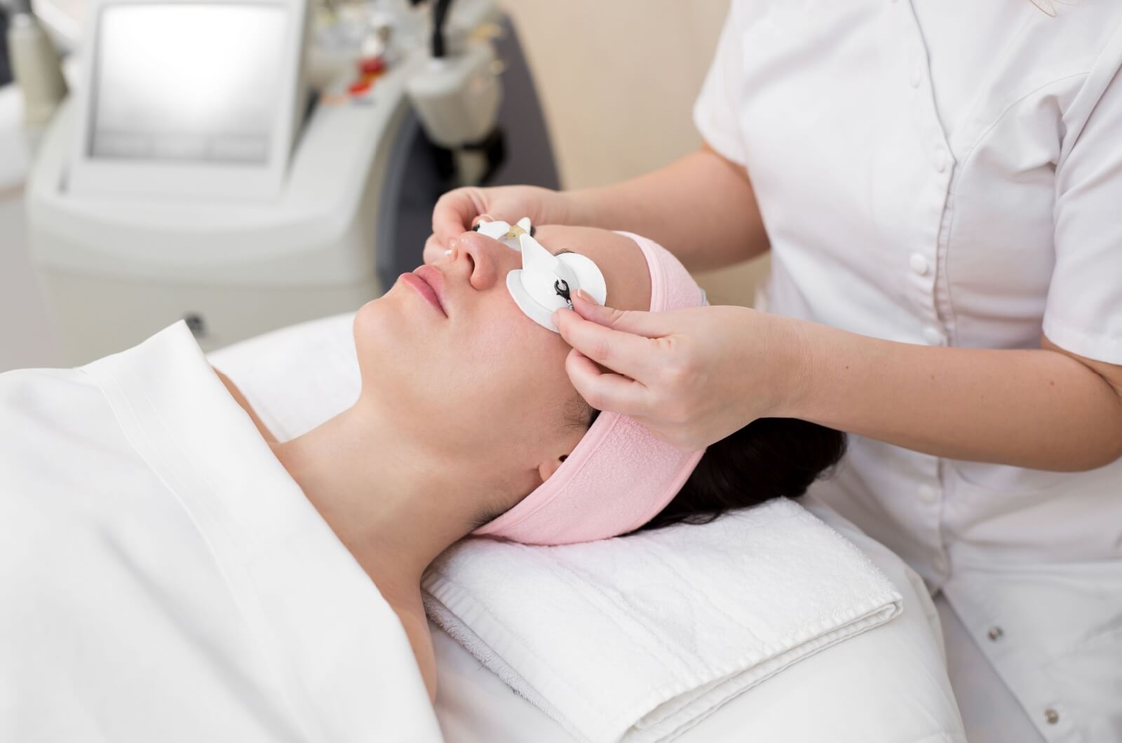 An eye doctor placing protective eyewear over a patients eyes before IPL treatment.
