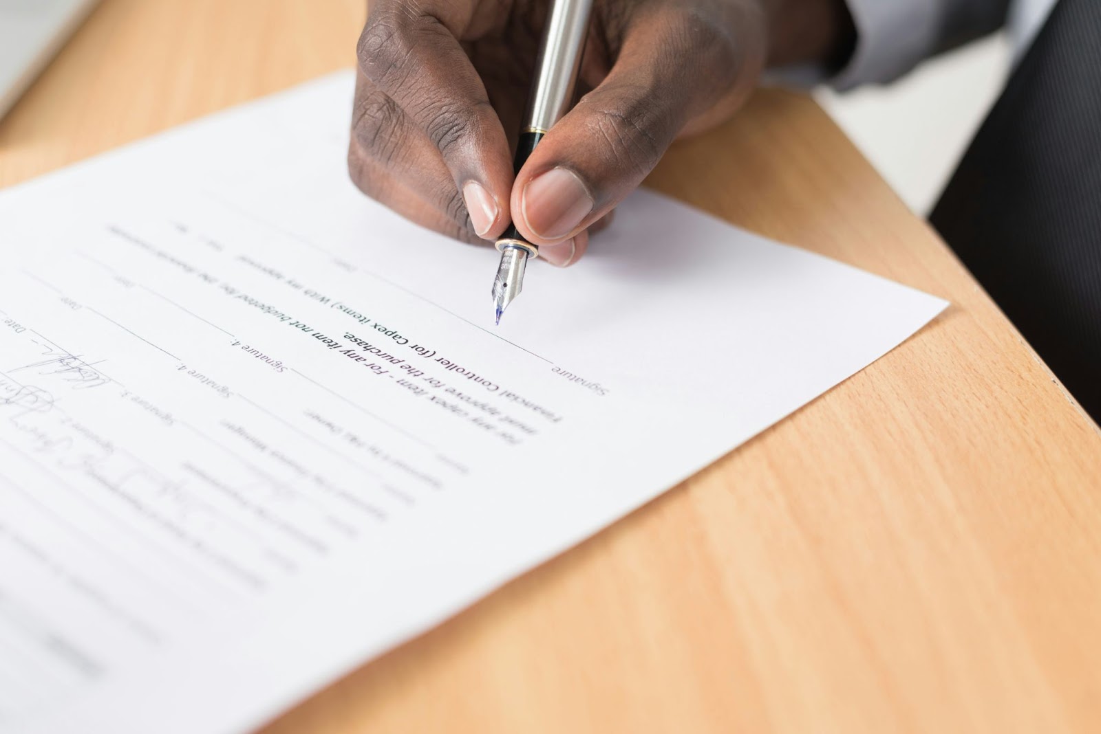 A close-up of a person signing a document