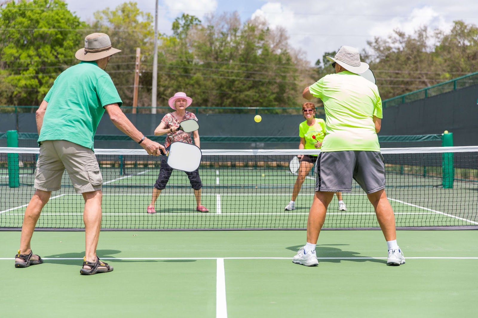 two men and two women playing pickleball