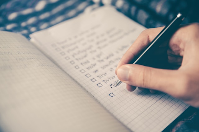 A person writing on a notebook with his plan