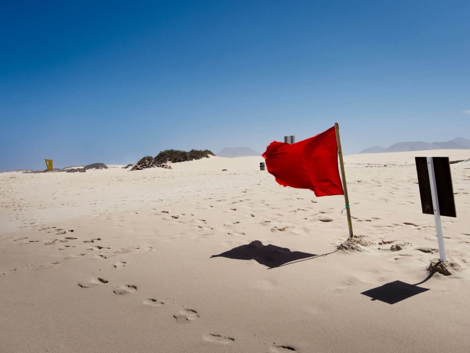 A red flag on a beach.