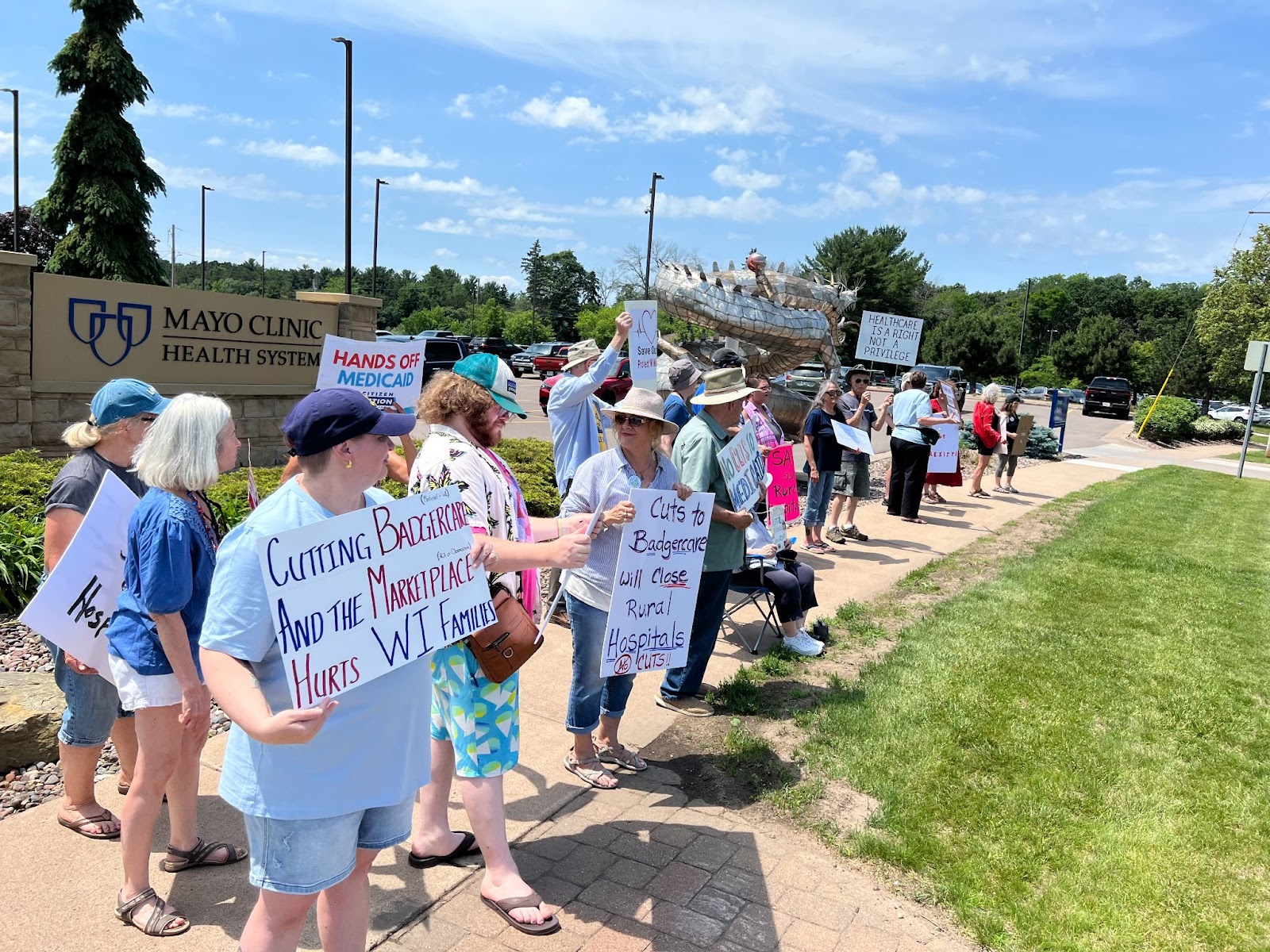 Dozens of protests hold signs in front of a hospital in Eau Claire, WI
