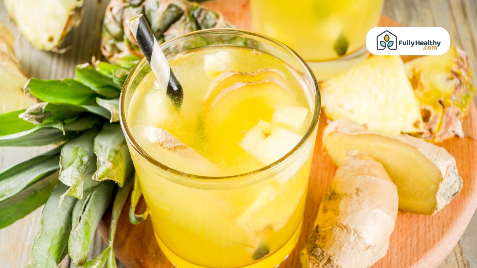 Pineapple ginger drink in glass with fresh ingredients on table