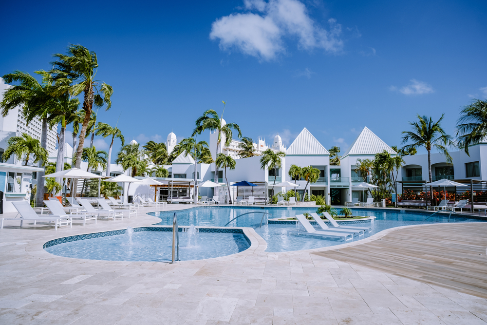 Resort pool with blowing palm trees