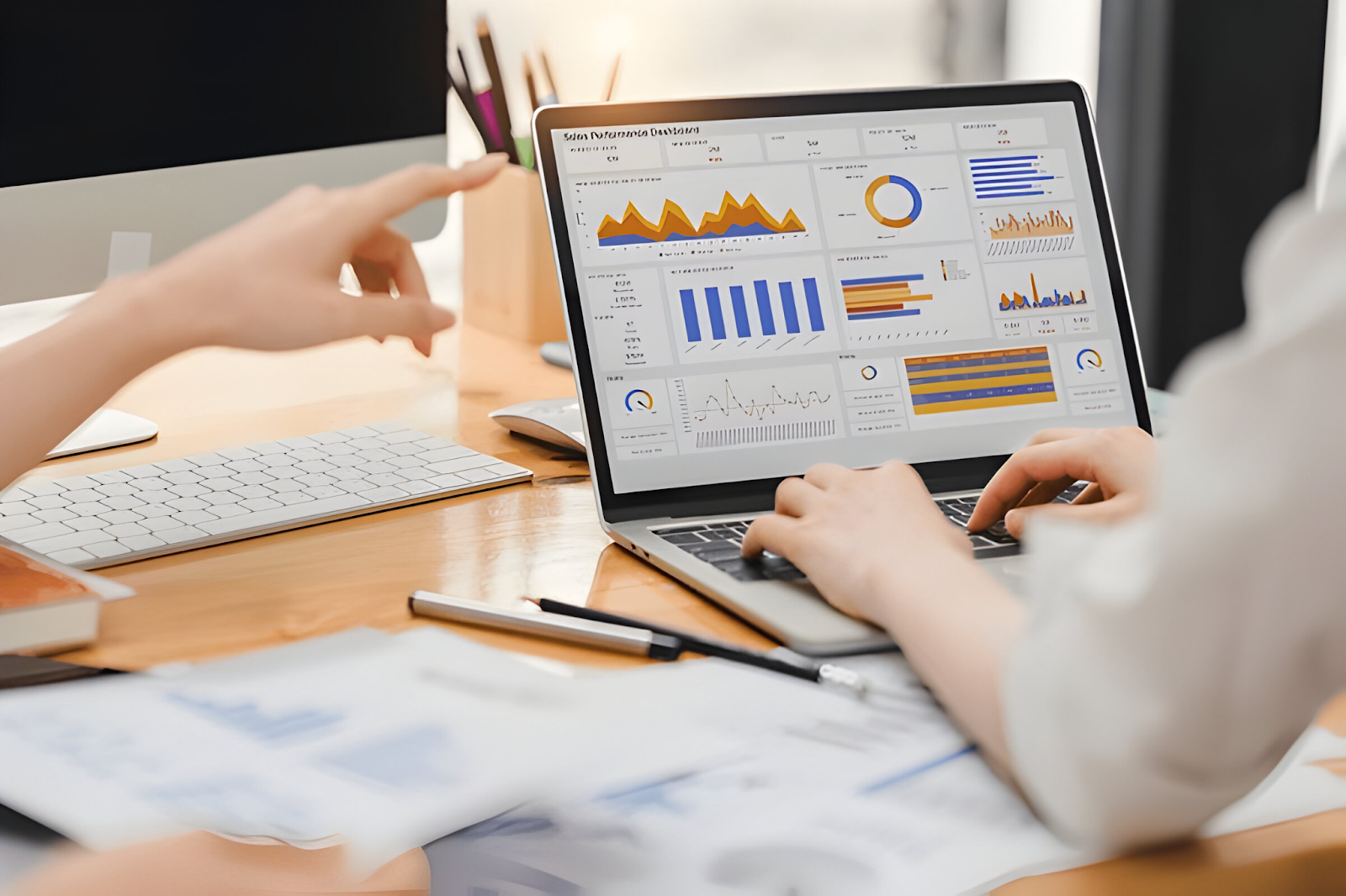 Accountants analyzing data charts and graphs on a laptop, representing the challenge of implementing and maintaining internal controls for financial accuracy.