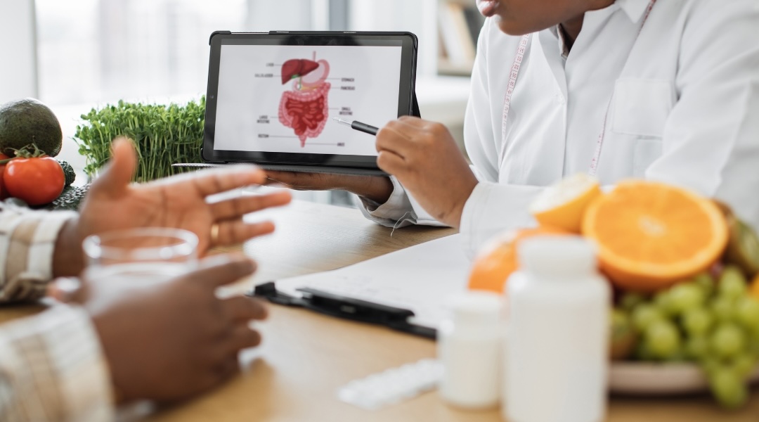 Toronto Nutritionist Dietitian using a device to analyse the gastrointestinal treatment of a male patient.