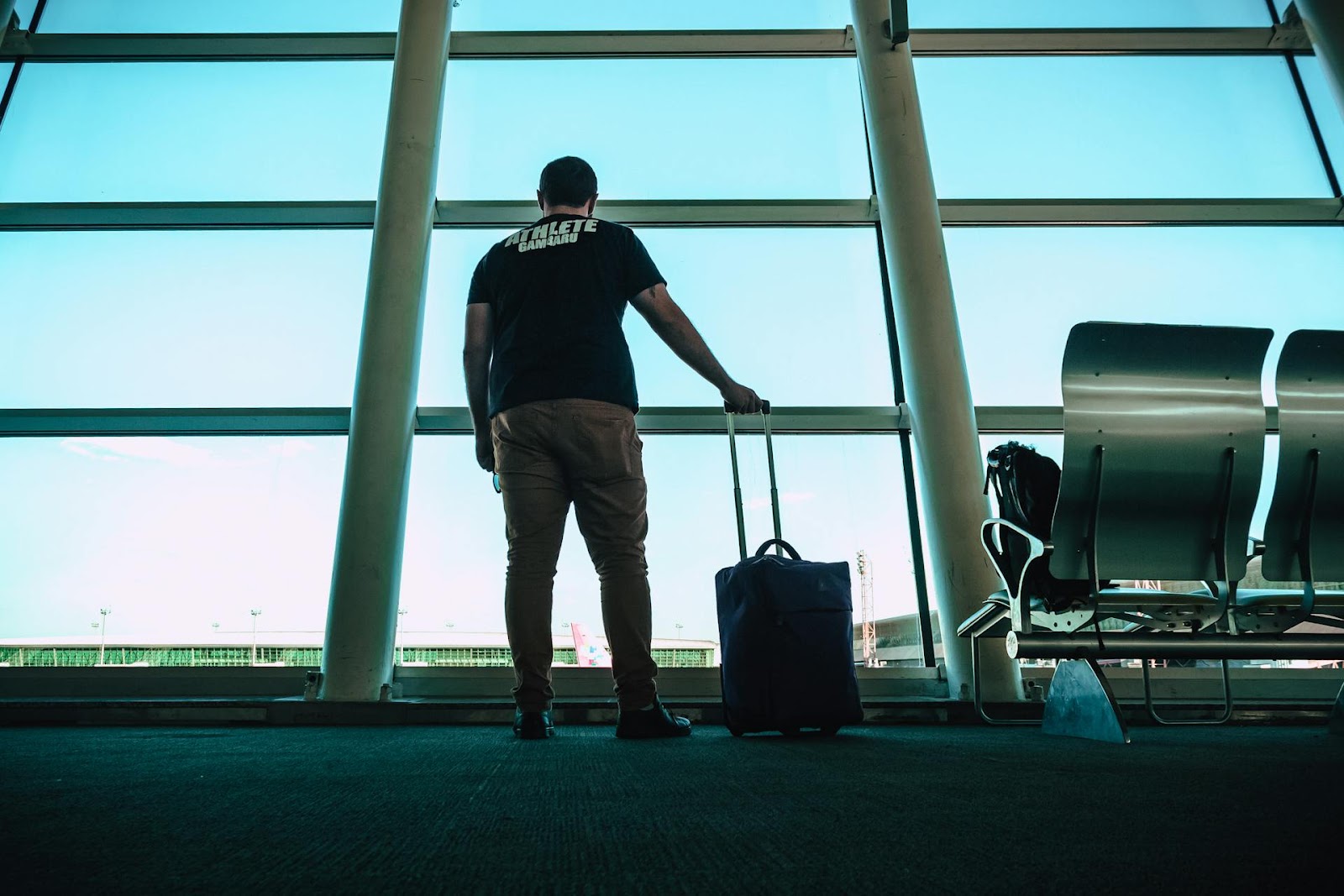 A man standing in an airport waiting lounge | Source: Pexels