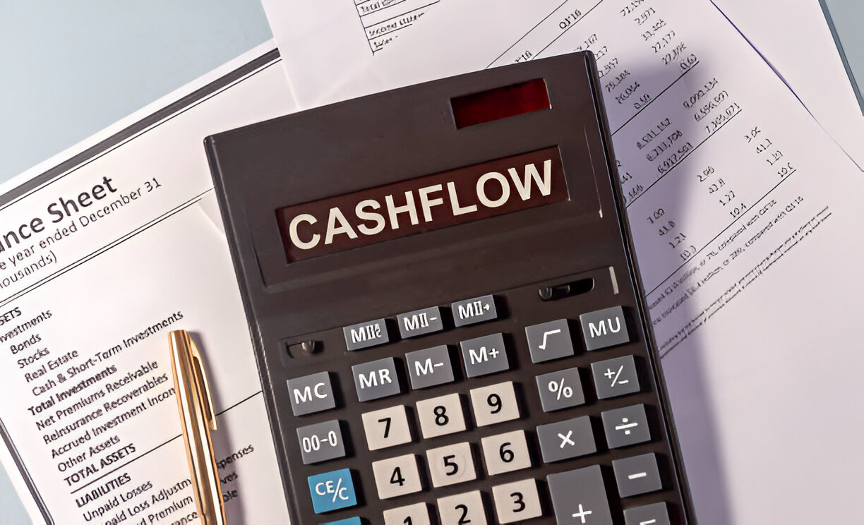 Calculator labeled 'Cash Flow' placed on top of financial documents, representing the cash flow statement in financial analysis.