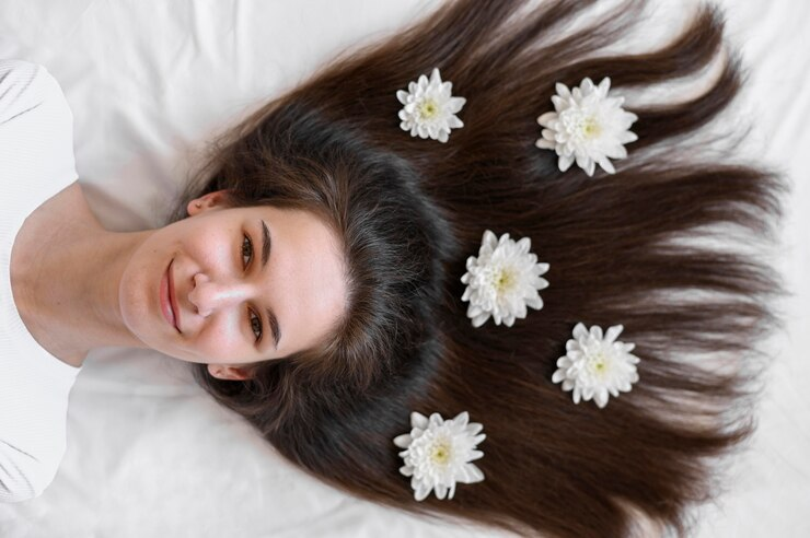 Female laying on bed with flowers in hair