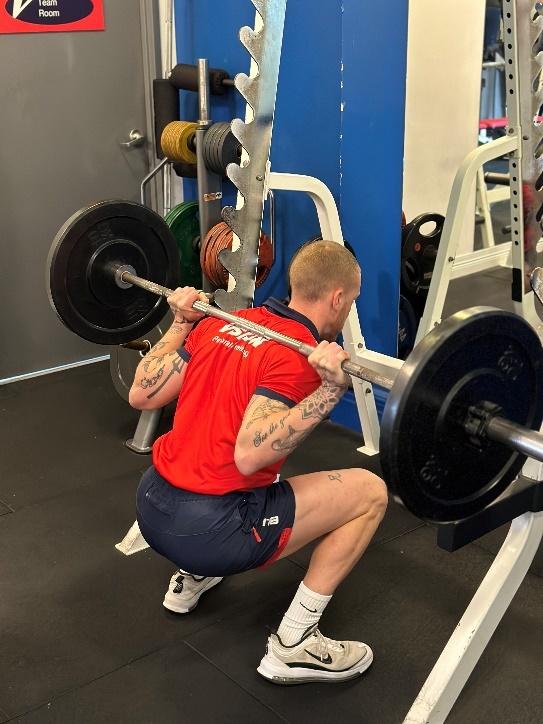 a Vision PT personal trainer performing barbell squats