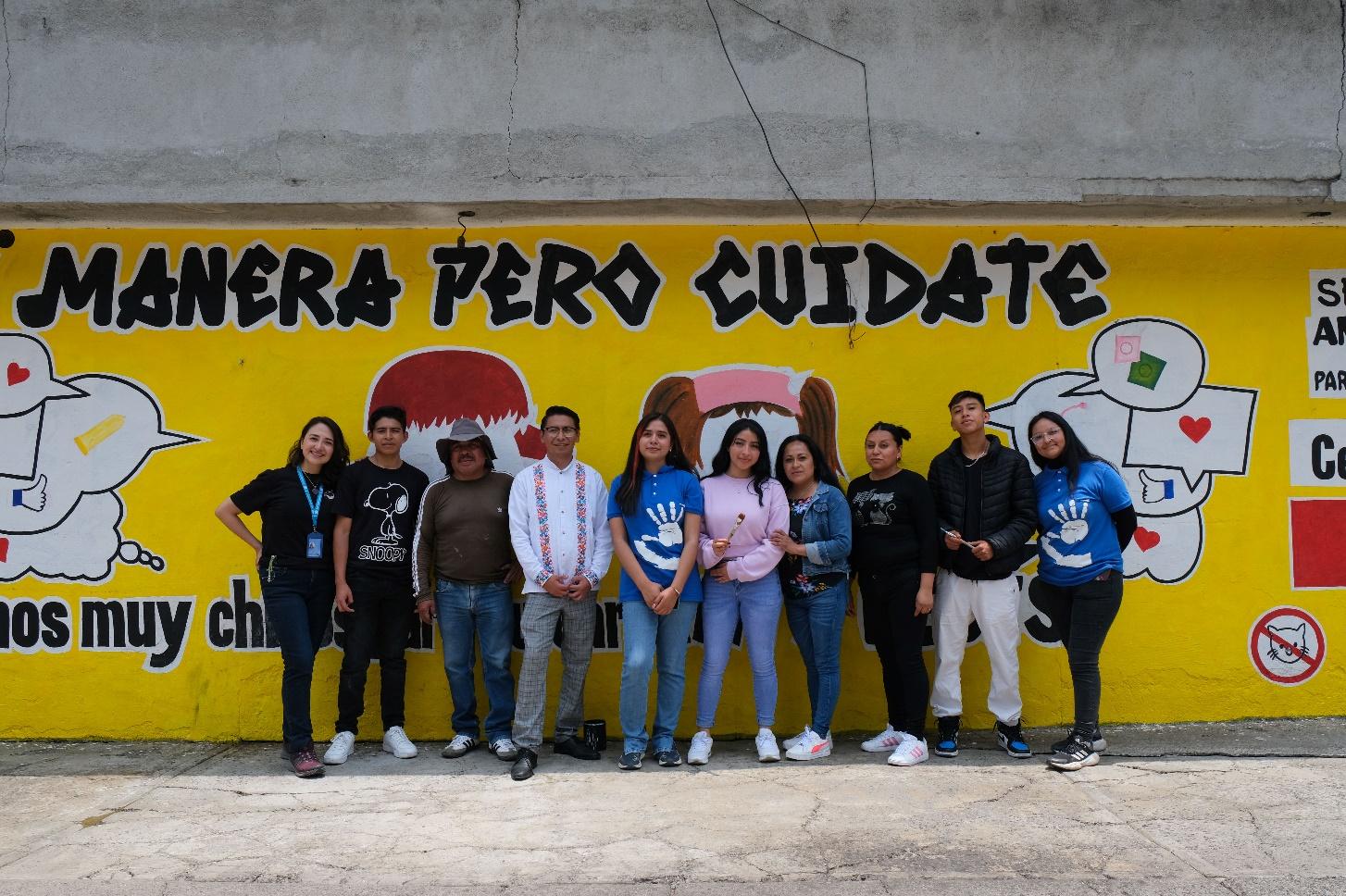 Un grupo de personas posando para la cámara delante de un cartel

Descripción generada automáticamente con confianza baja