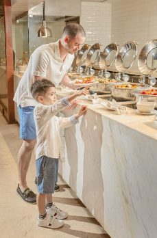 A person and child standing at a buffet

AI-generated content may be incorrect.