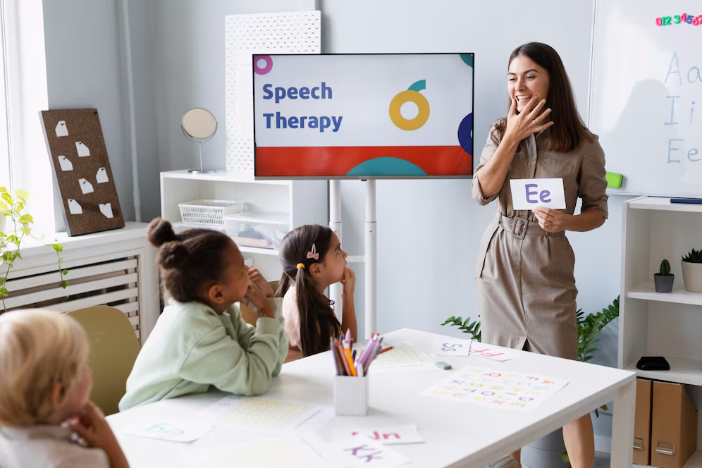 Speech therapist engaging with young children during a bilingual speech therapy session at Talk To Me Bilinguistics, showcasing educational materials and interactive learning tools.