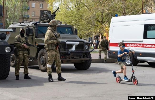 Российские военные на улице в оккупированном Мелитополе. 1 мая 2022 года. Фото: AFP (снимок сделан во время поездки в оккупированный город, организованный армией РФ)