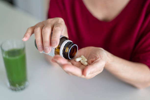 A person drinking a thyroid support supplement, symbolizing proactive care for thyroid wellness.