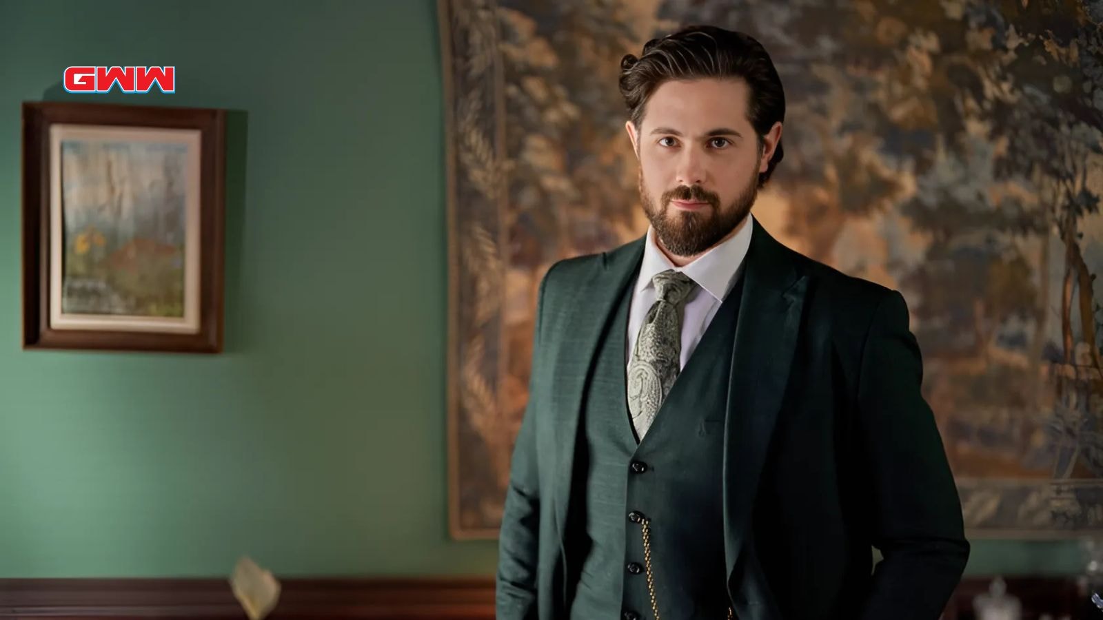 Lucas Bouchard dressed in a green suit, standing indoors.