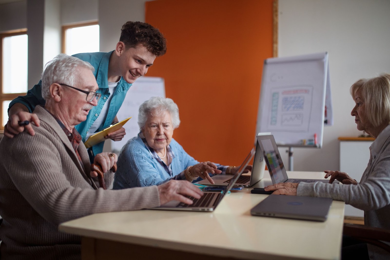 An instructor teaching a group of older adults how to use a computer.
