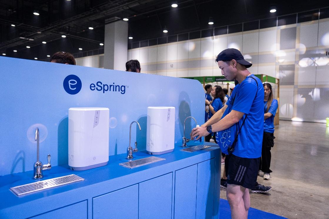 A person standing in front of a blue counter with white water dispensers

Description automatically generated