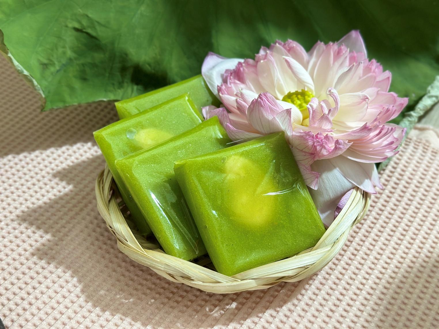 A green square shaped food in a basket next to a flower  Description automatically generated