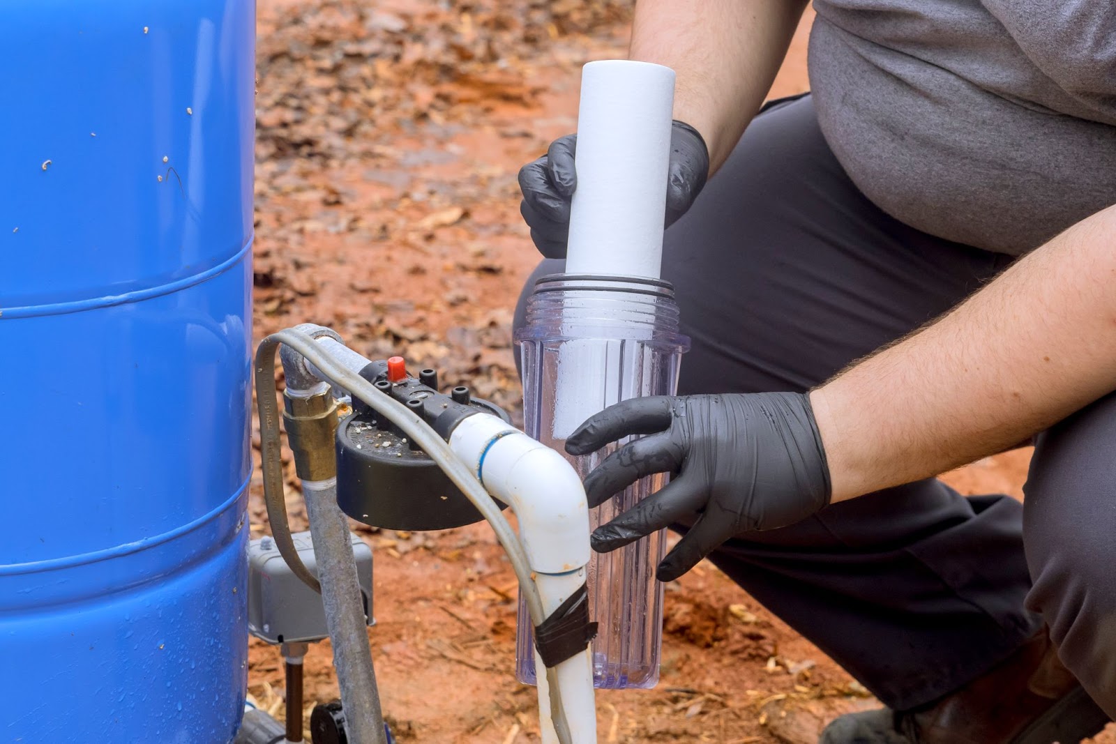 A technician installs a new water purification filter cartridge during routine maintenance.
