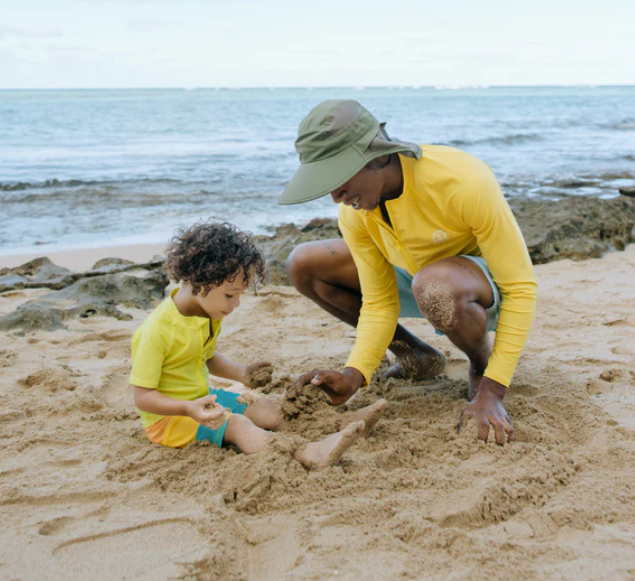 Dad wearing wide-brimmed sun hat by SwimZip with son at the beach—How wide should the hat brim be for sun protection?