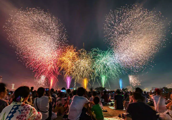 A group of people watching fireworksAI-generated content may be incorrect.