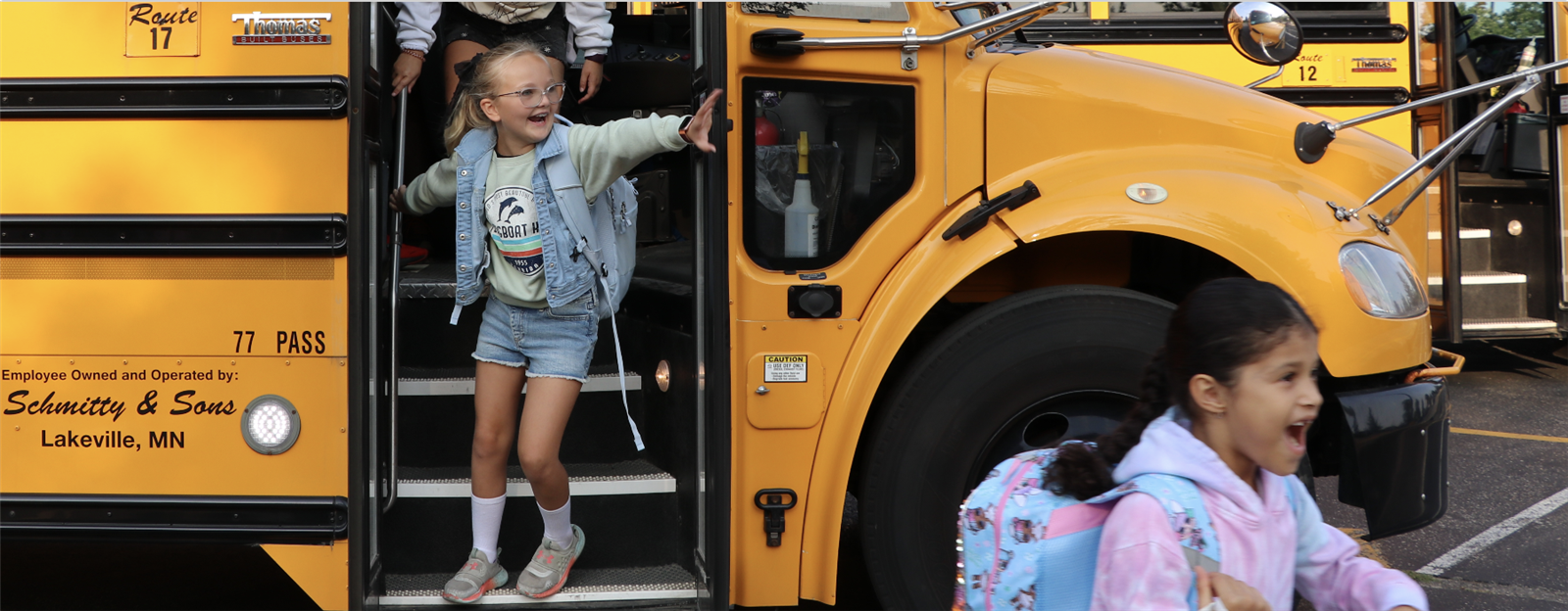 Student smiling while getting off the bus at school