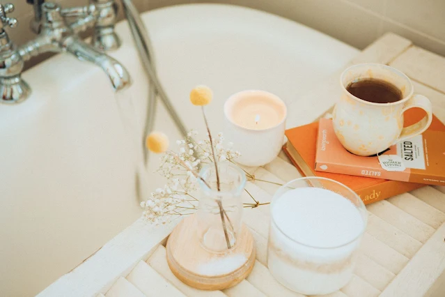 Woman relaxing in a warm bath, surrounded by soothing bubbles and candlelight