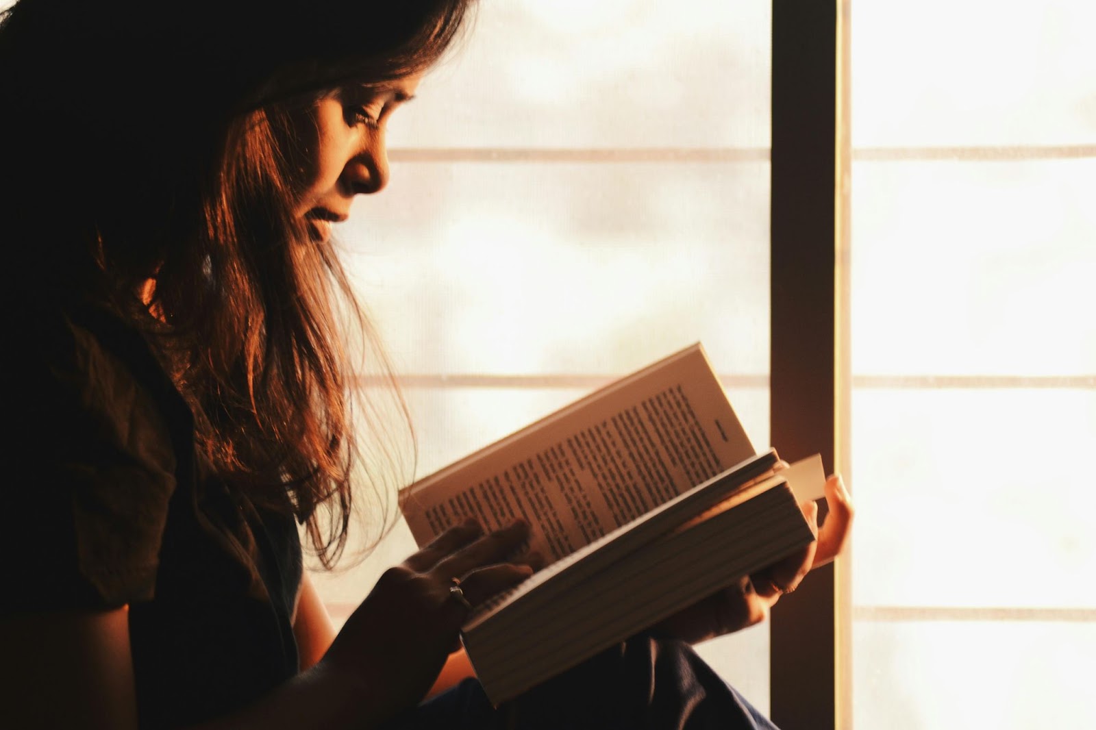 Woman reading book via Pexels.com https://www.pexels.com/photo/woman-reading-a-book-beside-the-window-1031588/