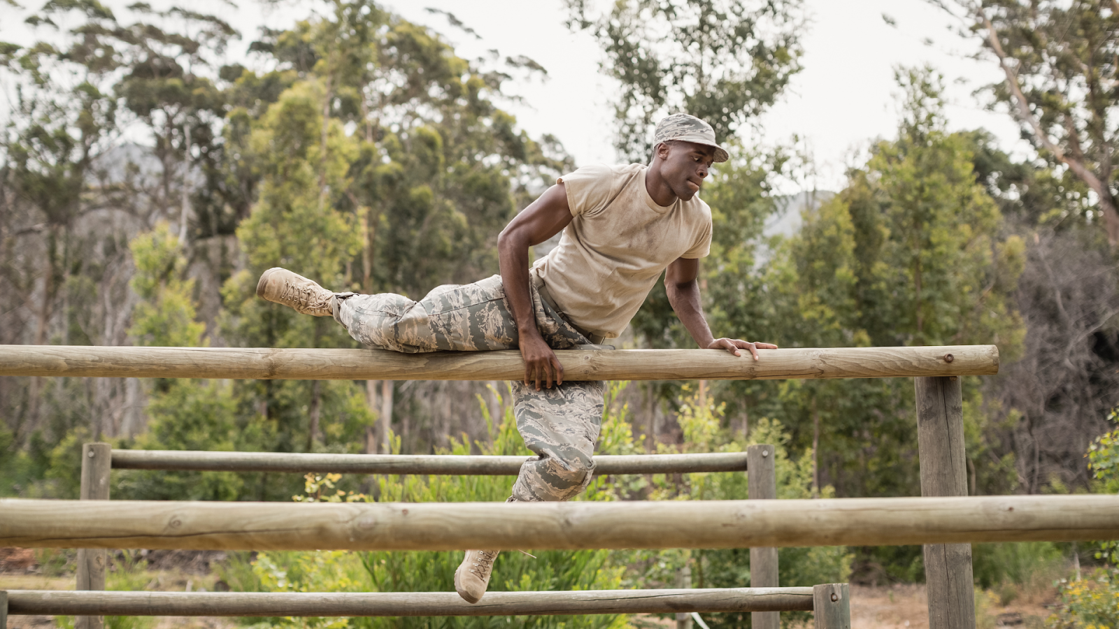 Military man busy training by jumping over wooden pole // Healthier Veterans Today