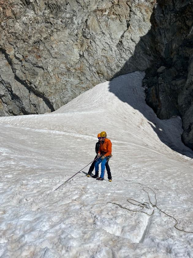 A person sitting on a snow covered mountainAI-generated content may be incorrect.
