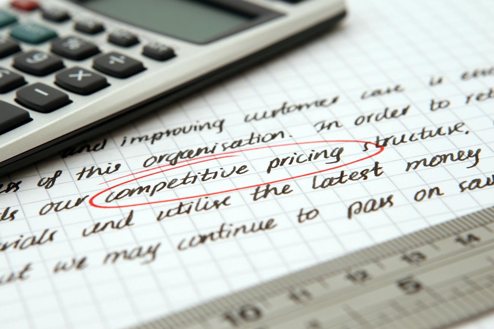 Focused image of handwritten business notes with calculator emphasizing pricing strategy.