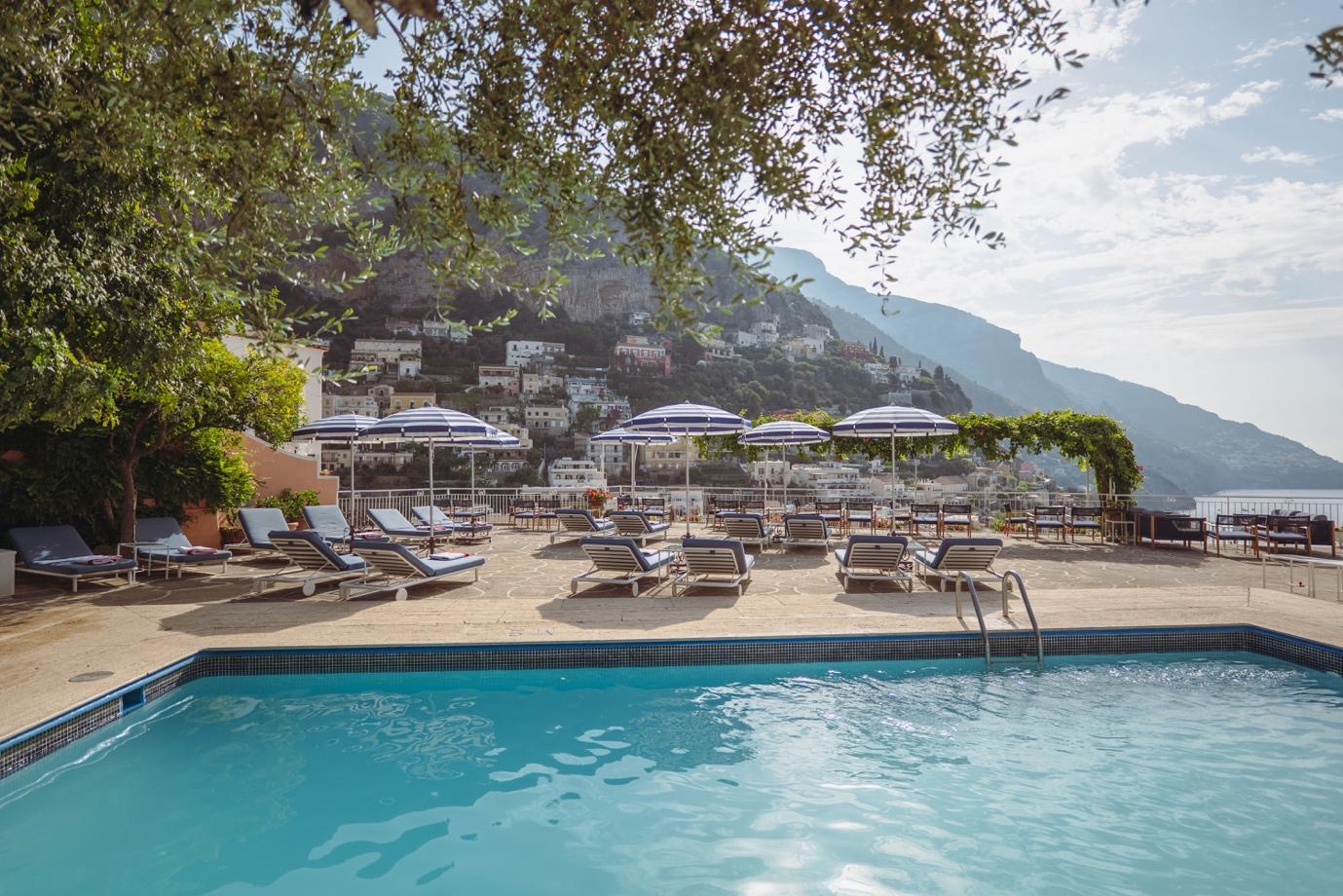 A pool with chairs and umbrellas

Description automatically generated