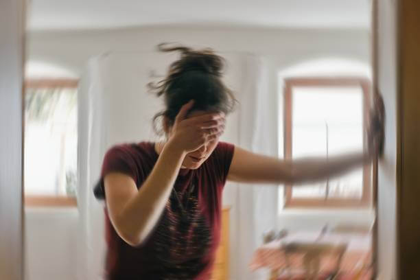 A woman with her hands on her forehead, visibly in discomfort, representing the pain caused by migraines.