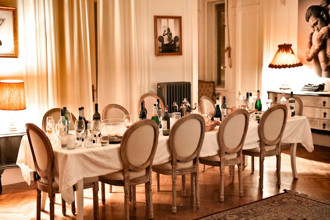 Free Luxurious dining room setup with bottles and glasses after a dinner party. 