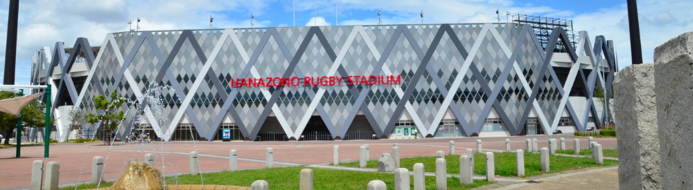 ダイヤ柄外観が特徴的な「HANAZONO RUGBY STADIUM」を正面から撮影した全景