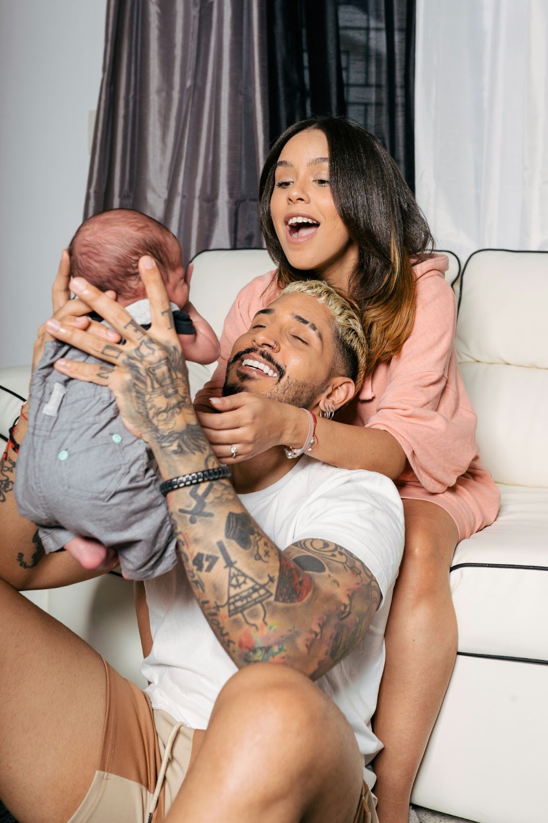 A man and woman looking at their baby smiling.