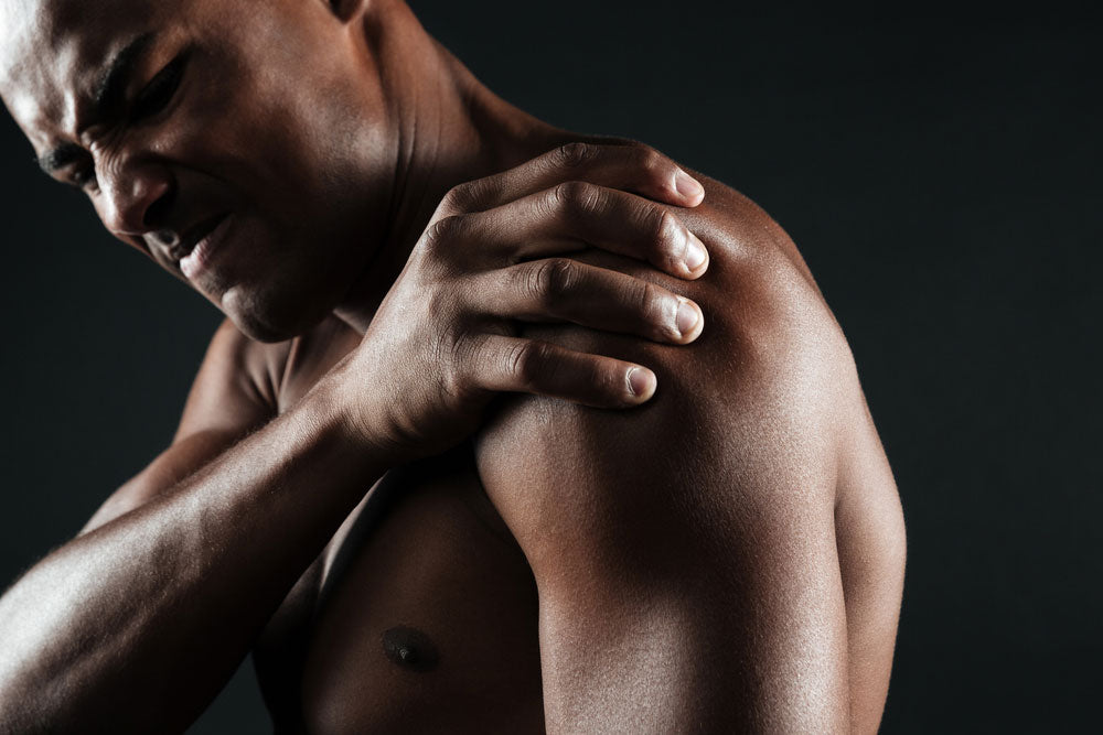 man in holding shoulder in pain