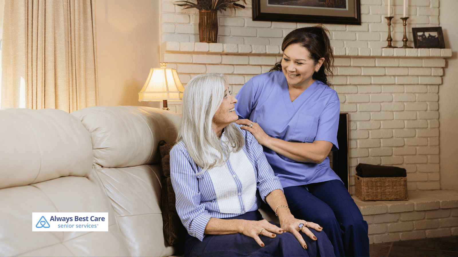 This image depicts a caregiver talking to a senior woman smiling