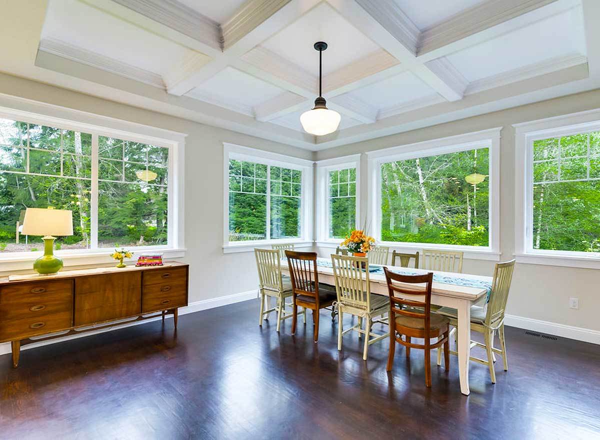 An ample amount of natural light flows in the dining area through the white-framed windows.