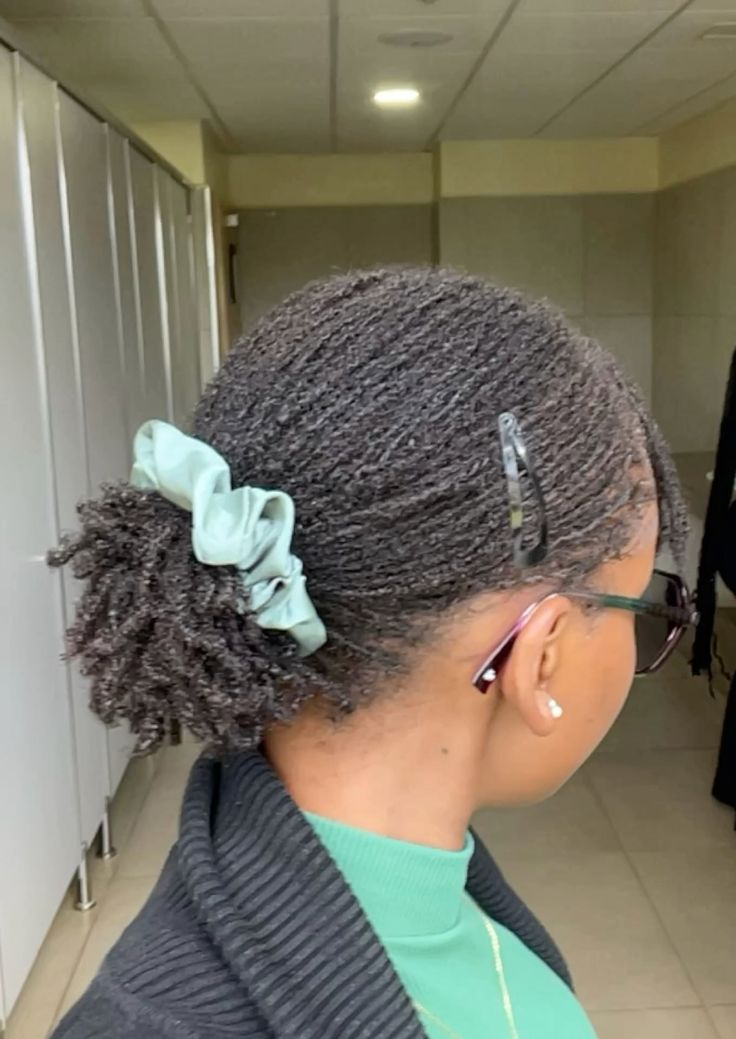 a lady rocking large microlocs styled with a scrunchie