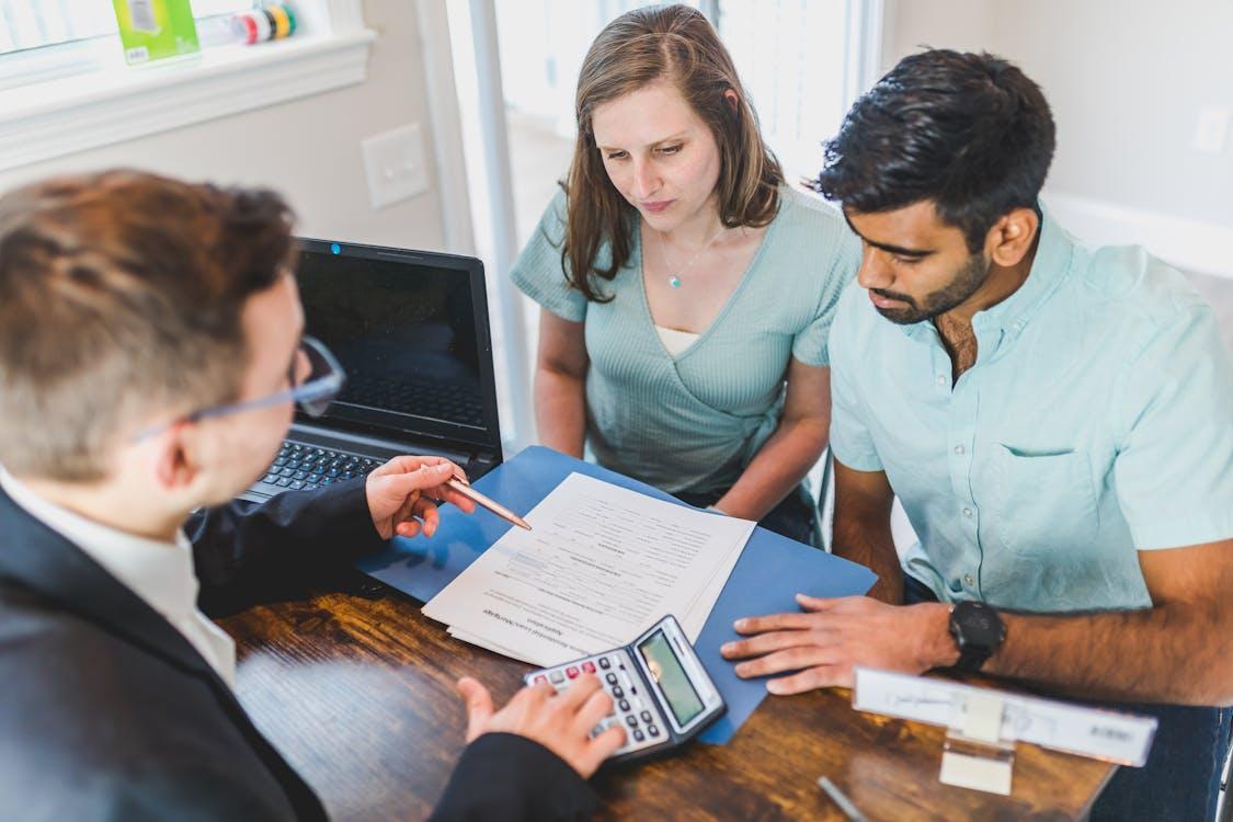 Free Young couple meeting with real estate agent to discuss property purchase. Stock Photo