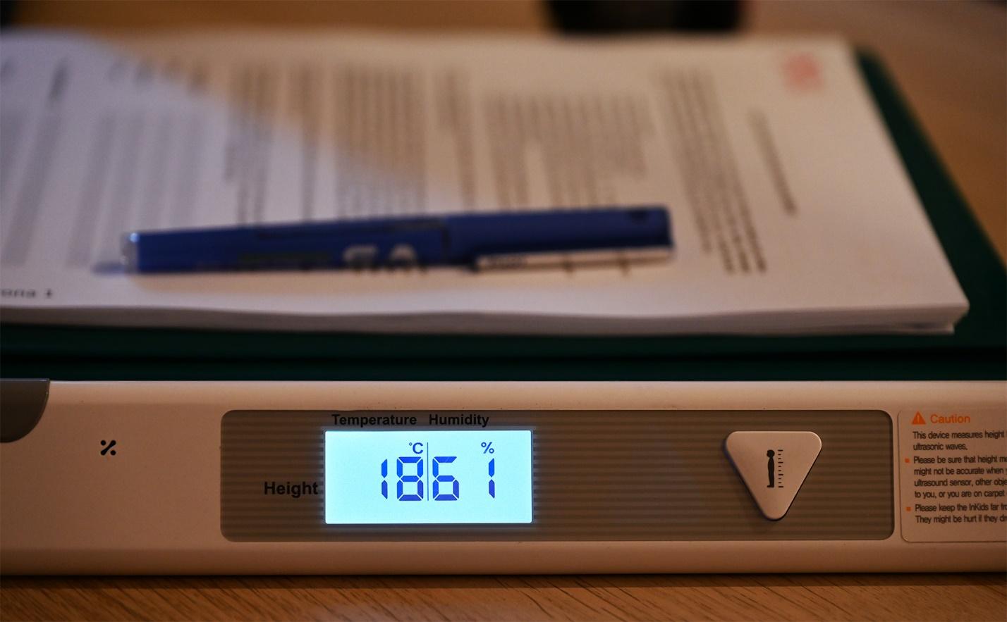 A scale with a blue screen and a pen on top of it

Description automatically generated