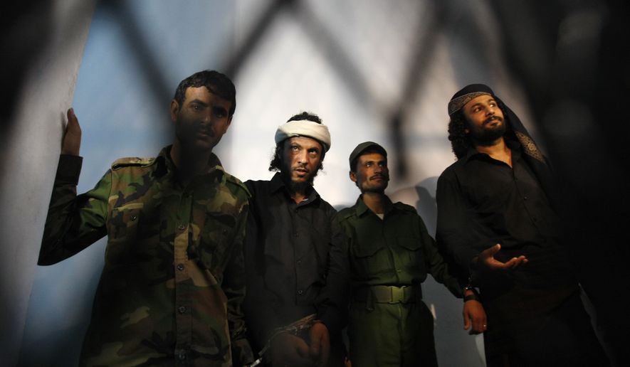 A group of suspected al Qaeda militants accused in the killing of an army general in a suicide bombing stand trial at a state security court in Sanaa, Yemen, in this April 22, 2014 file photo. (Associated Press) **FILE**