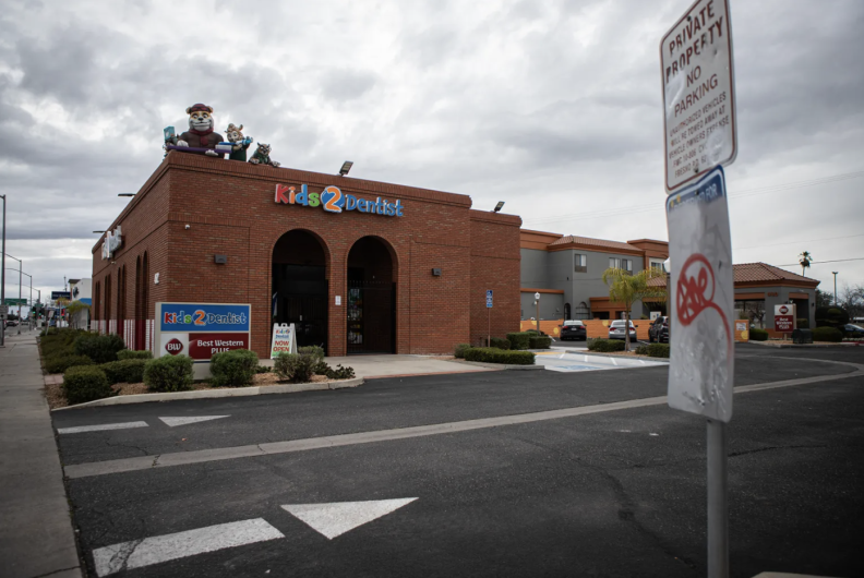 A brick building bears the letters "Kids 2 Dentist" in various colors. 