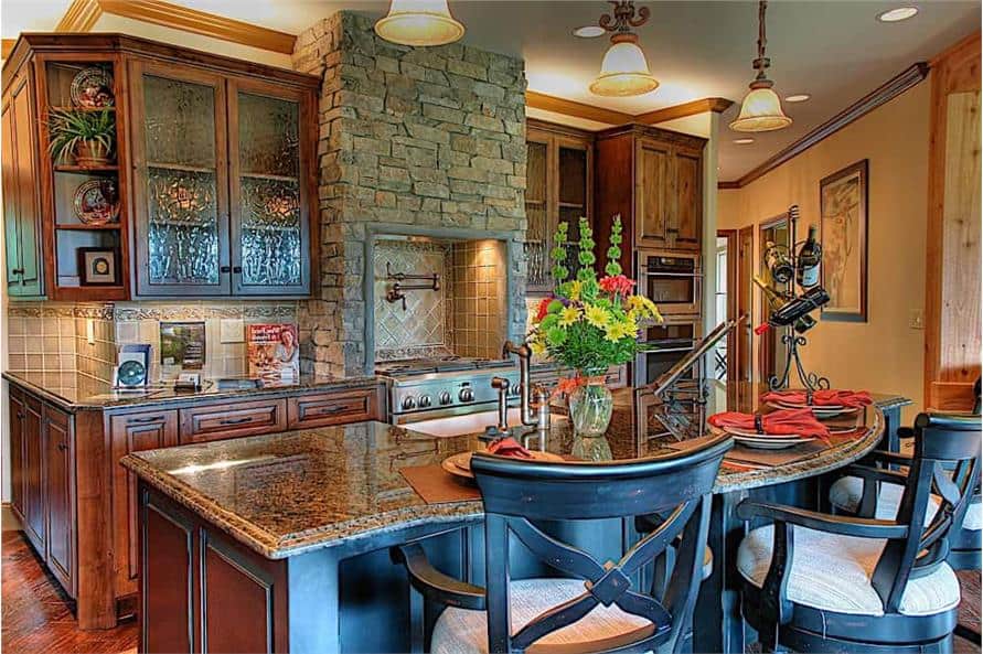 The kitchen offers dark wood cabinetry, a stone cooking alcove, and a breakfast island paired with cushioned counter chairs.