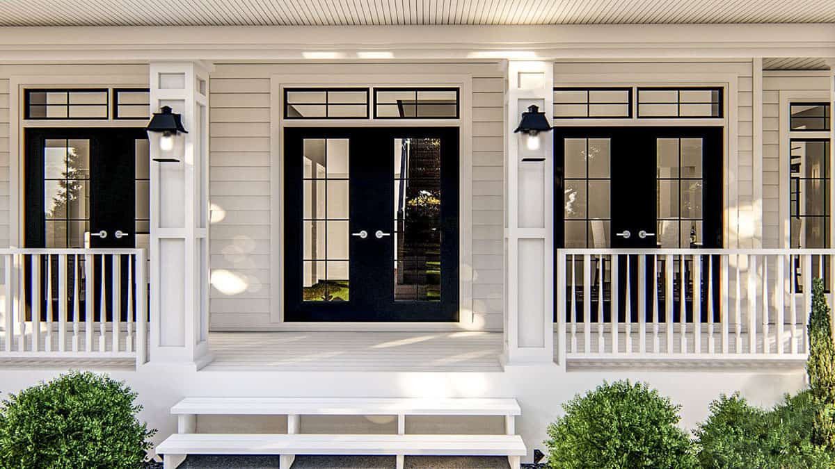 A closer look at the covered entry porch with a wooden stoop and French doors.