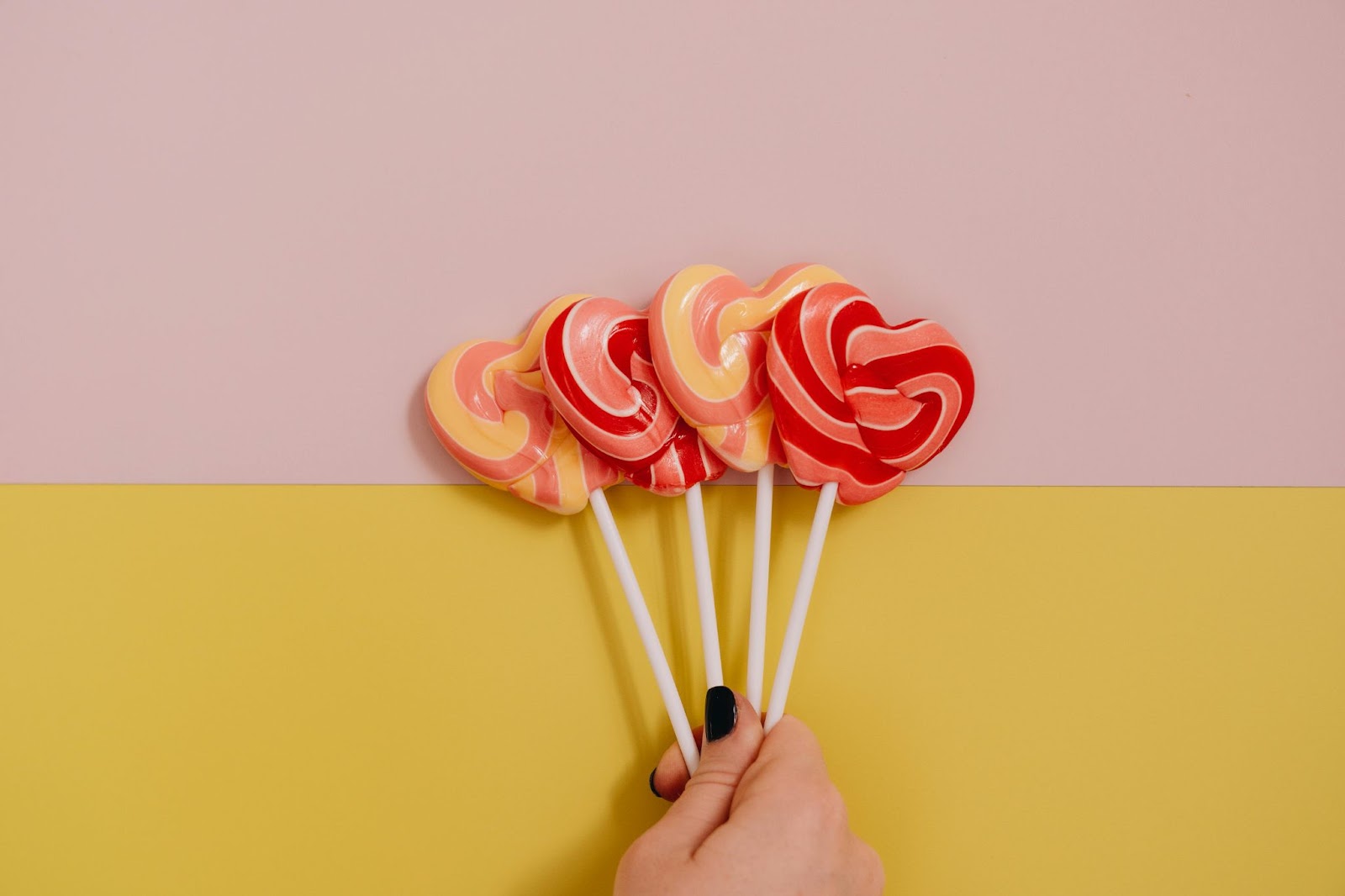 Hand Holding Heart Shaped Lollipops